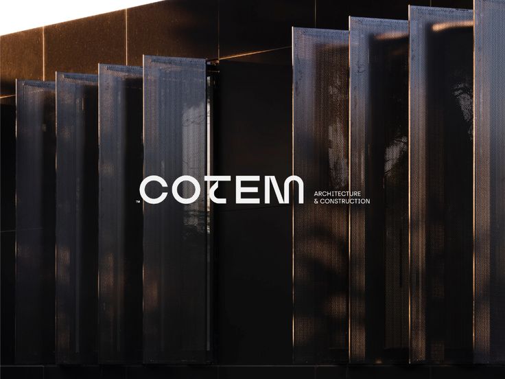 the side of a black building with white lettering that reads, coten on it