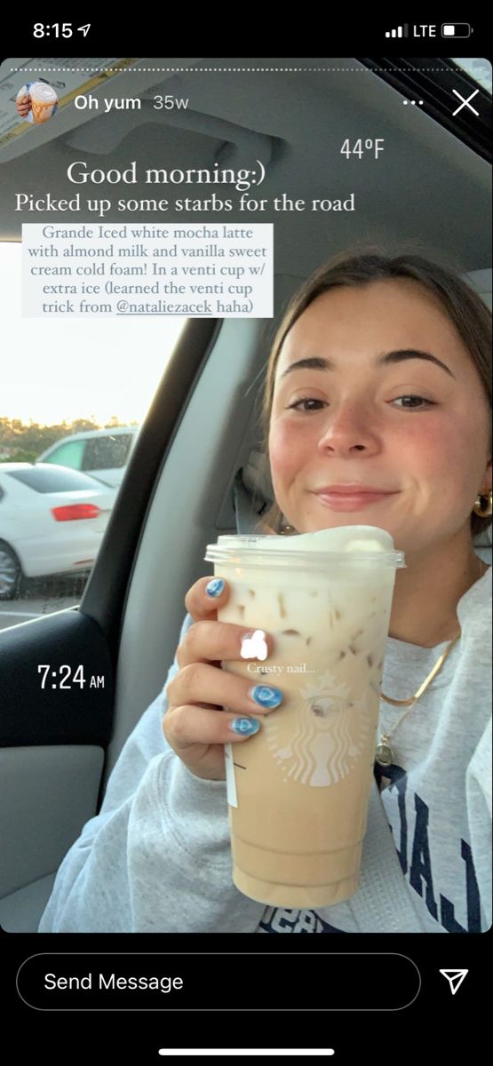 a woman sitting in the back seat of a car holding up a cup of coffee