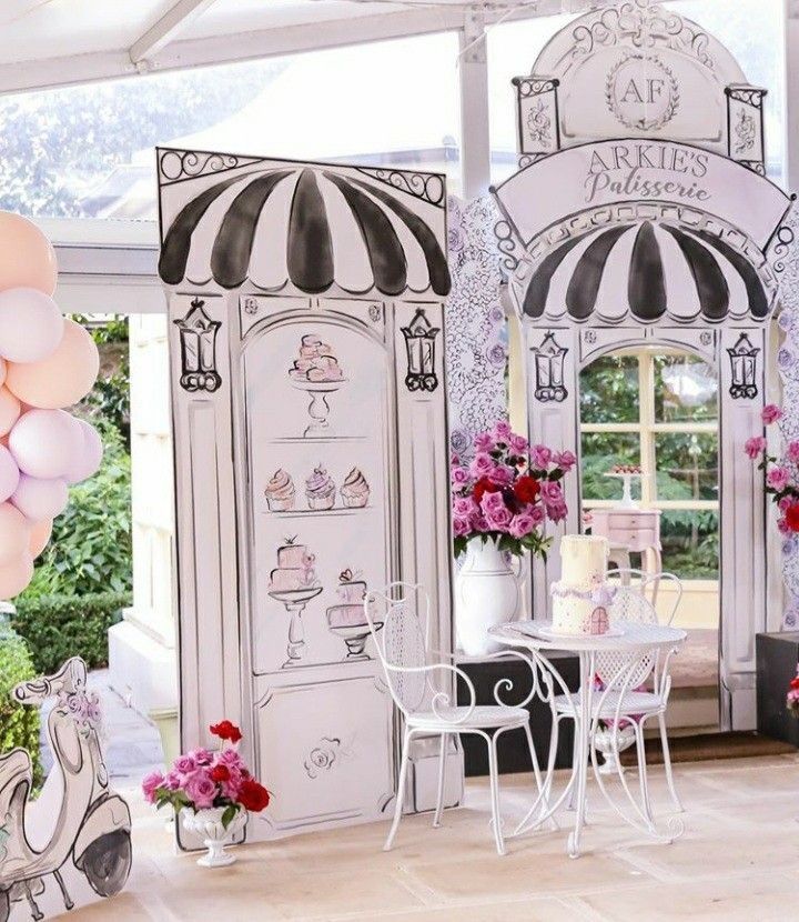 a room filled with balloons and furniture next to a wall covered in pink and white decorations