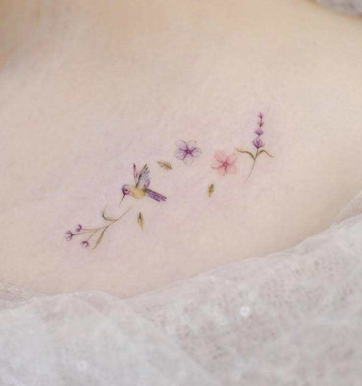 three small flowers on the back of a woman's left side ribcage