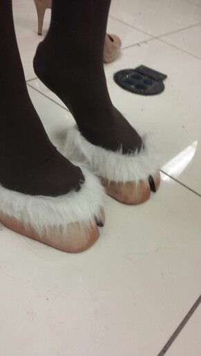 a pair of feet in furry slippers on the floor