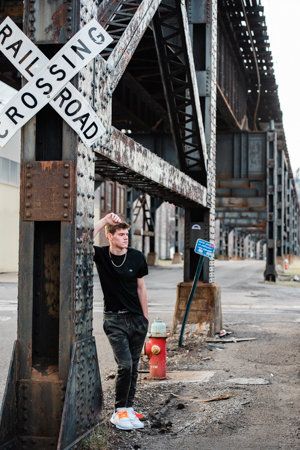 a man standing next to a railroad crossing sign