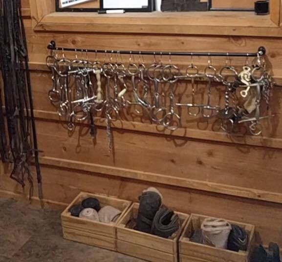 several pairs of shoes are hanging on the wall in front of a window with hooks