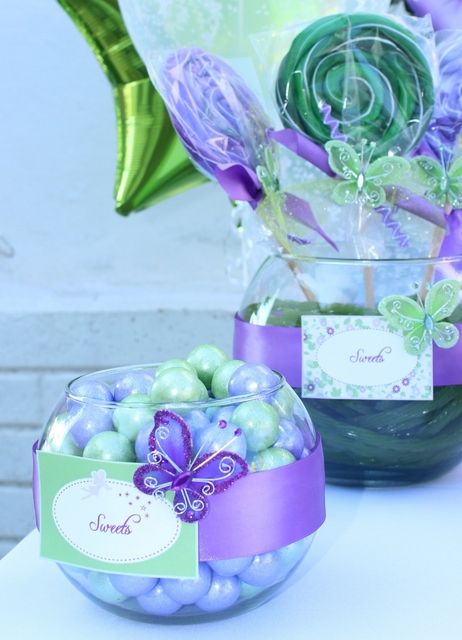 two glass vases filled with candy and flowers