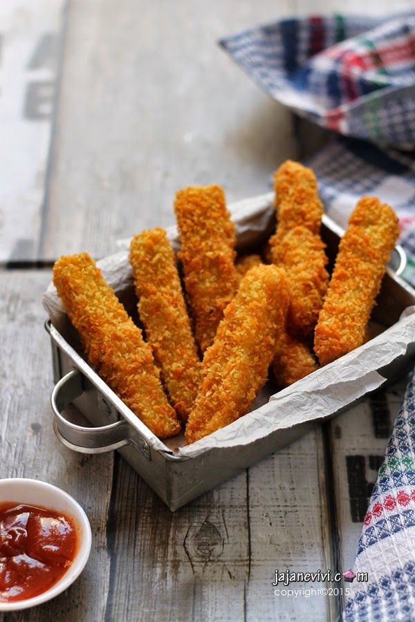 some fried food in a metal container next to sauce on a wooden table with napkins