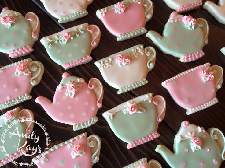 decorated cookies in the shape of teapots and kettles on a wooden table