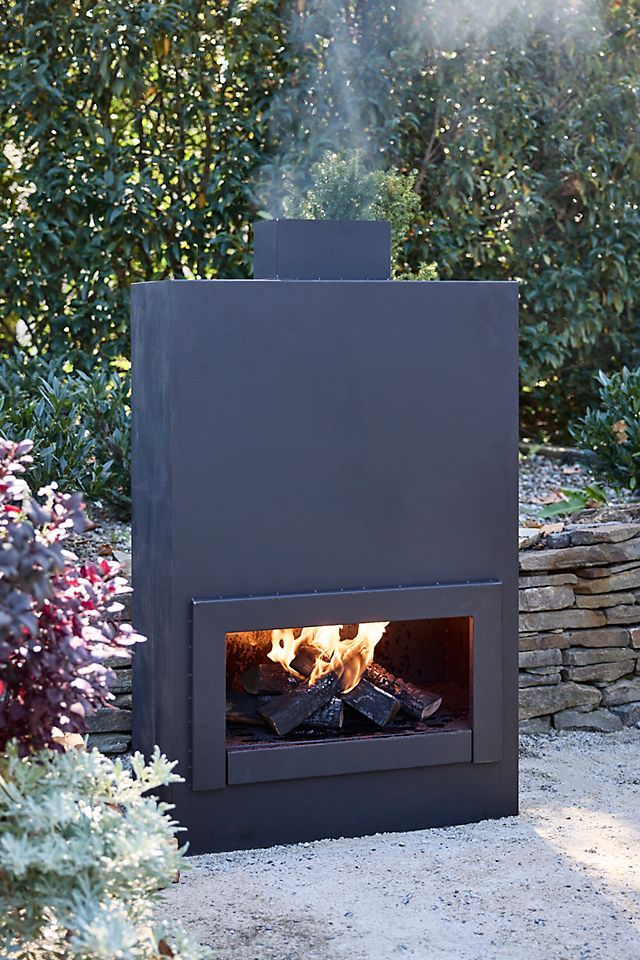 an outdoor fireplace in the middle of a garden