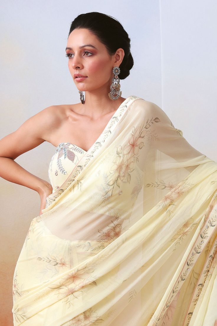 White lined saree with floral print and embroidered border. Paired with zardozi, mirror embroidered bordered padded bustier and petticoat.
Component: 3
Pattern: Printed, Embroidery
Type Of Work: Floral, zardozi, mirror
Neckline: Sweetheart
Fabric: Chiffon, Silk
Color: White
Other Details: 
Strapless bustier
Smocked back
Occasion: Reception - Aza Fashions Bollywood Style Pre-draped Saree With Sheer Dupatta For Summer, Summer Wedding Georgette Blouse Piece, Summer Wedding Pre-draped Saree With Zari Work, Summer Wedding Pre-draped Saree With Sheer Dupatta, Georgette Saree With Floral Embroidery For Wedding, Designer Georgette Saree For Summer, Floral Embroidered Georgette Saree For Wedding, Summer Georgette Designer Saree, Designer Summer Georgette Saree