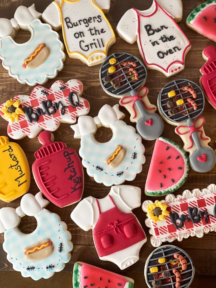 some decorated cookies are laying on a wooden table with the words burgers on the grill