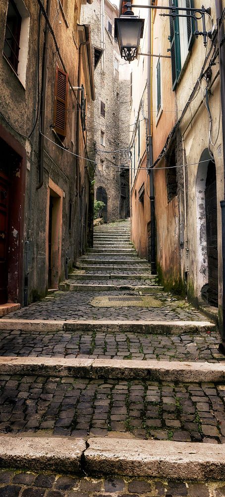 an alleyway with stone steps leading up and down