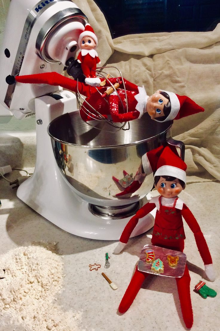 two elfs in red and white outfits are next to an electric mixer on the counter