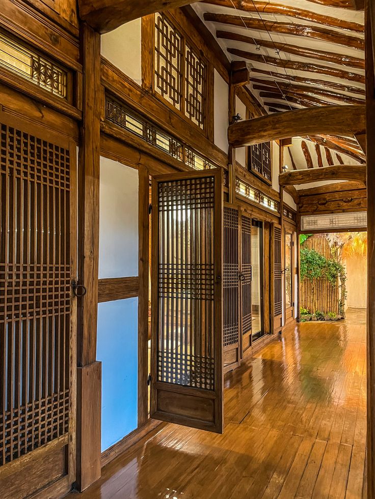 an empty room with wooden doors and windows