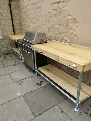 an outdoor bbq with two grills and shelves on the side of a building