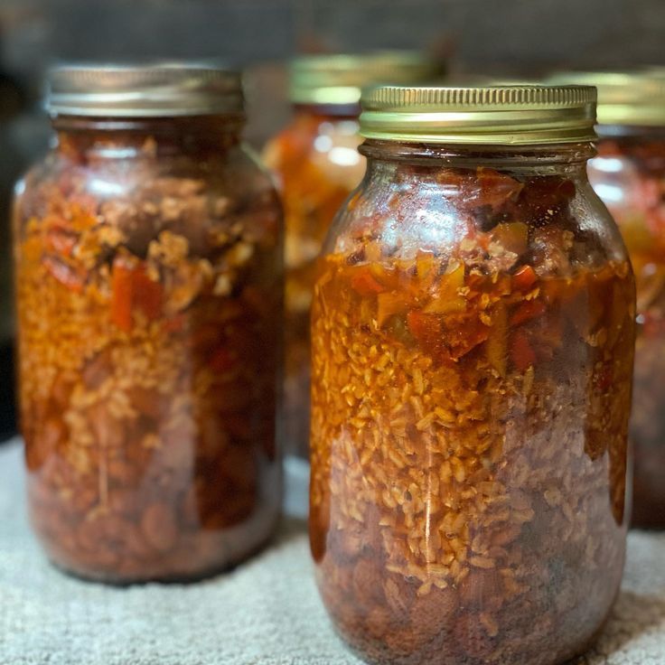 three jars filled with food sitting on top of a table