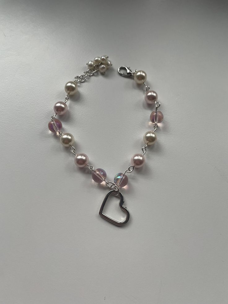 this pearl charm bracelet comes with a sterling silver heart charm, white and pink pearls, pink glass beads, and an adjustable clasp. this is a perfect gift for a loved one or for Valentine's Day! Heart-shaped Beaded Pearl Bracelet Gift, Adjustable Pearl Bracelets With Heart Charm, Pearl Heart Bracelet Gift, Pearl Beaded Bracelets With Heart Beads, Pearl Heart Bracelet For Valentine's Day Gift, Silver Heart-shaped Pearl Bracelet For Gift, Pearl Bracelets With Heart Beads, Pearl Heart Bracelet With Charm, Adjustable Pearl Bracelet With Heart Beads For Valentine's Day