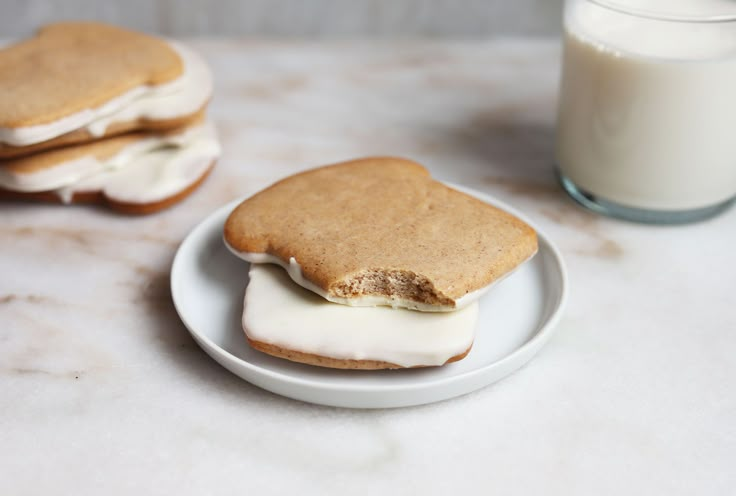 two cookies and a glass of milk on a table