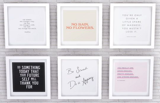 four framed quotes on a brick wall