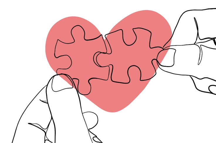 two hands holding puzzle pieces in the shape of a heart with one hand touching it