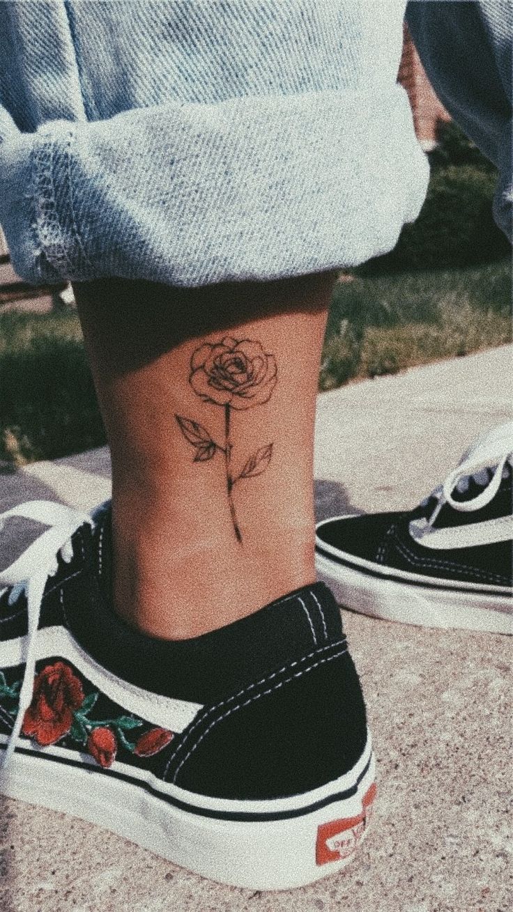 a woman's foot with a rose tattoo on her left side ribcage