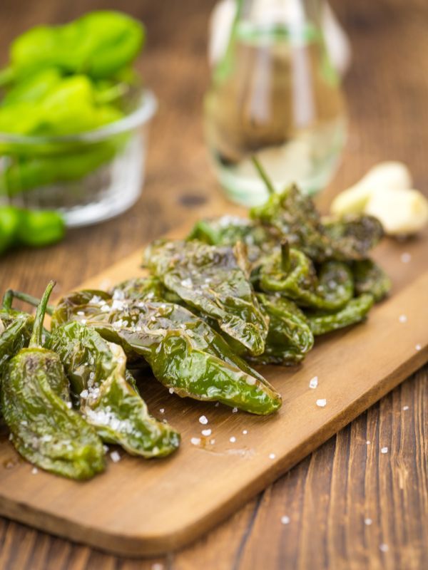 some green peppers on a wooden cutting board