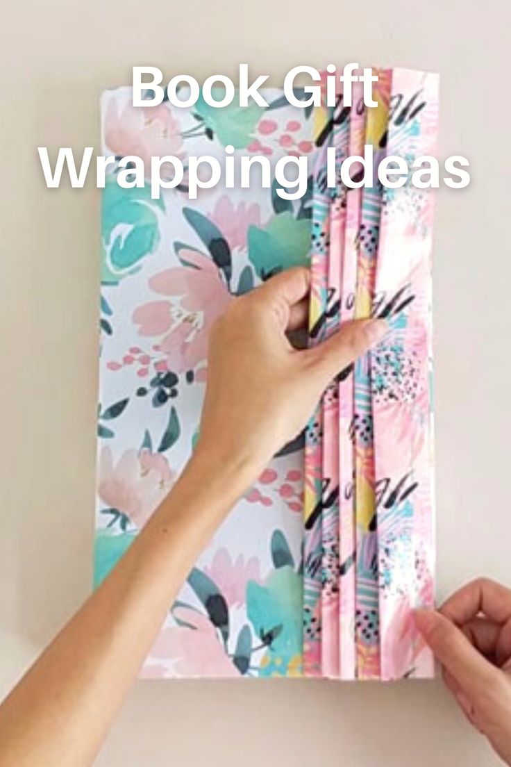 a person holding up a book with wrapping paper on it and the words book gift wrapping ideas