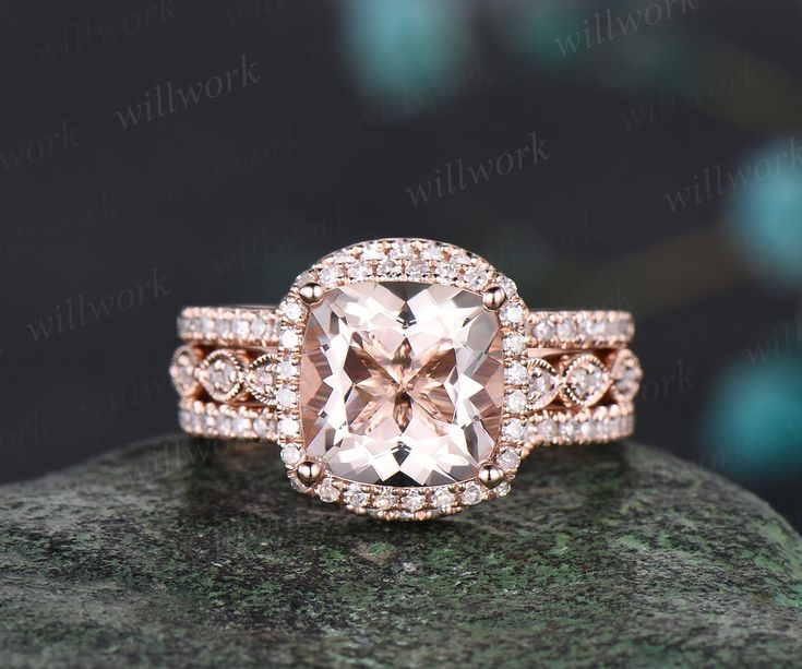 an engagement ring with a large pink diamond surrounded by small diamonds on top of a rock