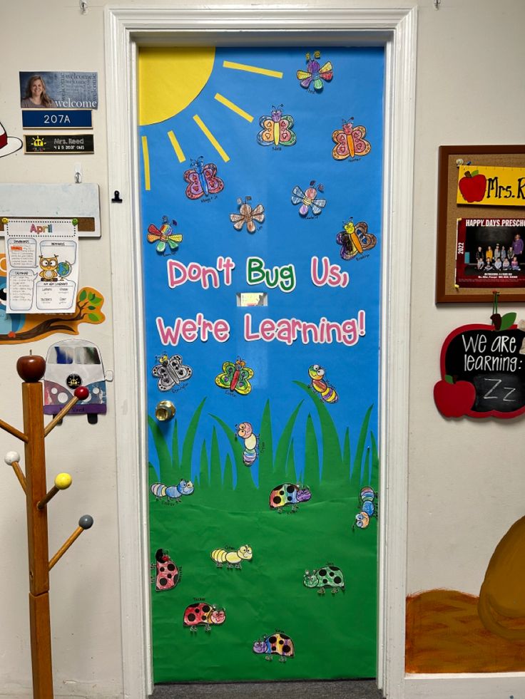 a classroom door decorated with magnets saying don't bug us, we're learning