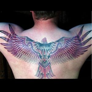 the back of a man's neck with a bird tattoo on it