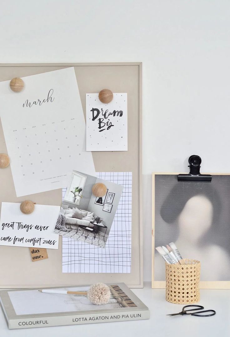 a bulletin board with pictures and magnets on it next to a small wooden box