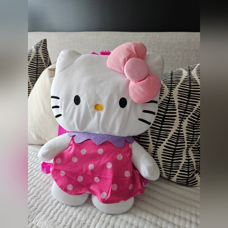 a hello kitty stuffed animal sitting on top of a bed