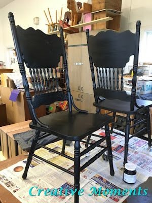 two black chairs sitting next to each other on top of a table