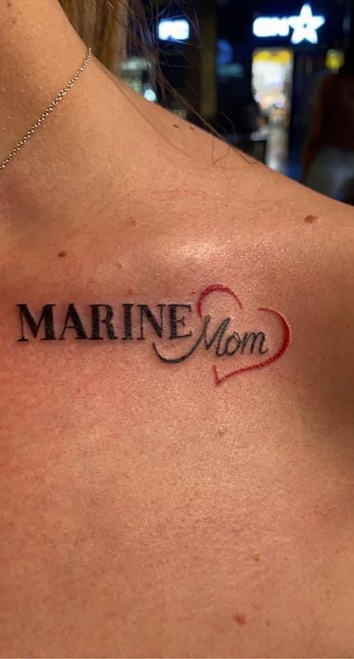 a woman's chest with the word marine mom tattooed on her left side shoulder