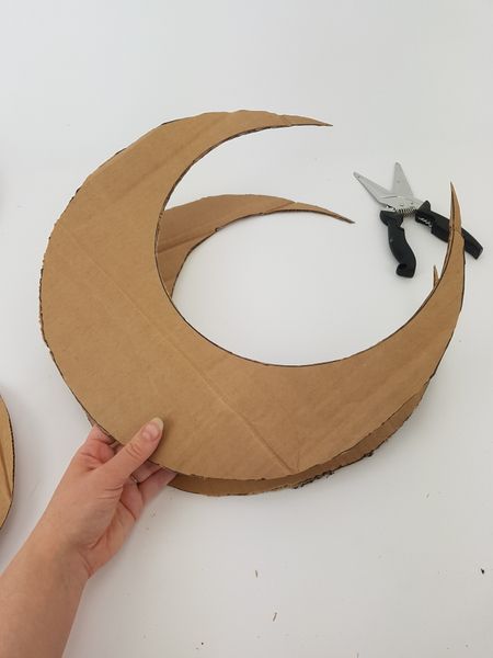 someone is making a cardboard moon with scissors