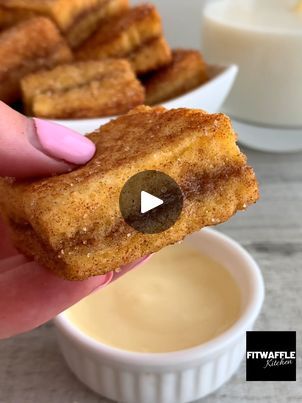 someone is holding up a piece of bread with an appetizer in the background