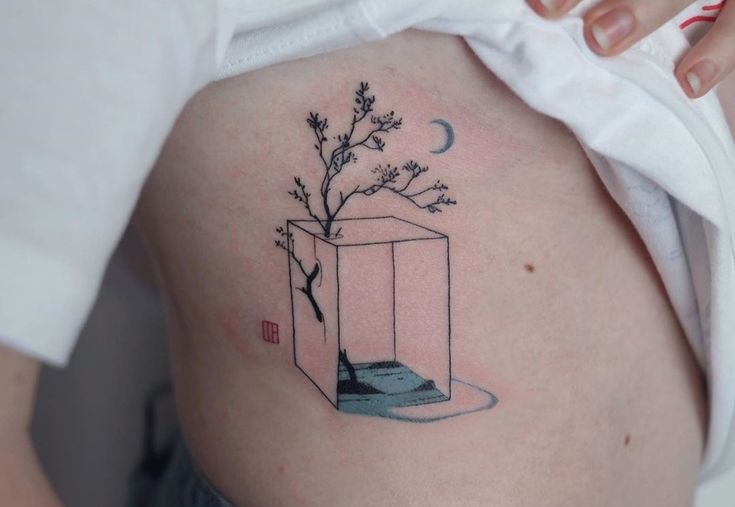 a woman's stomach with a small tattoo on it that has a tree in a vase