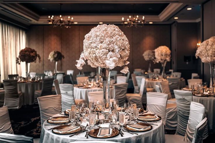 the tables are set with silver and white linens