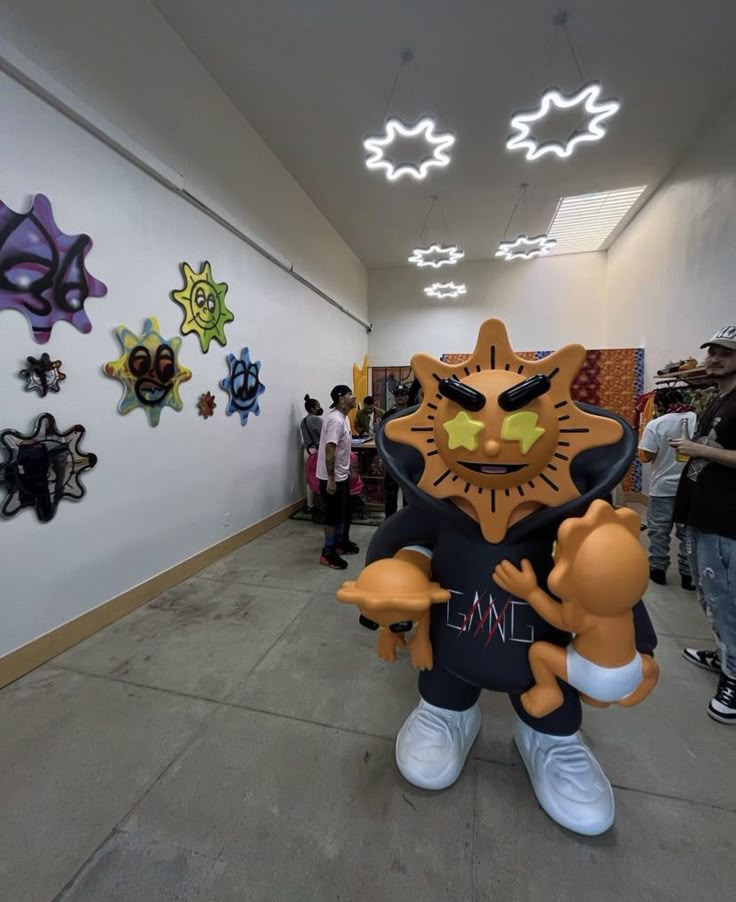 an inflatable cat is standing on the floor next to some people wearing masks