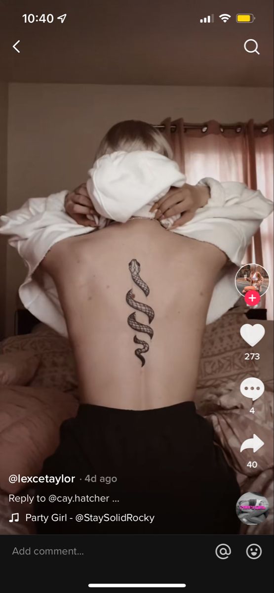 the back of a person with a tattoo on their left side and an image of a snake