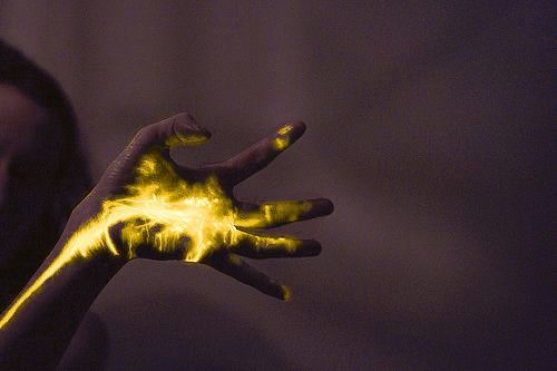 a woman holding her hand up with yellow paint on it