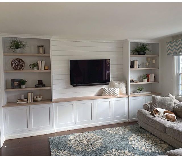 a living room filled with furniture and a flat screen tv mounted on the wall above it