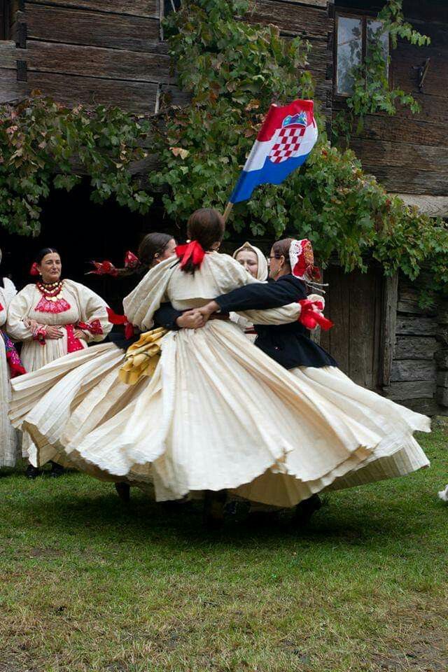 some people are dancing in the grass and one is wearing a dress with a flag on it