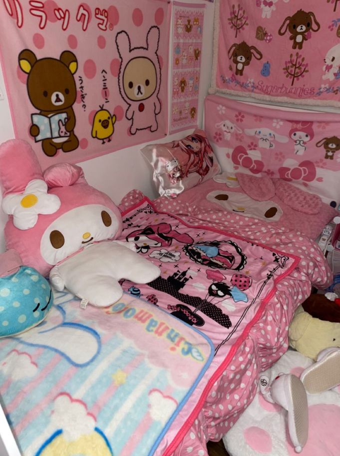 a bedroom with hello kitty bedding and stuffed animals