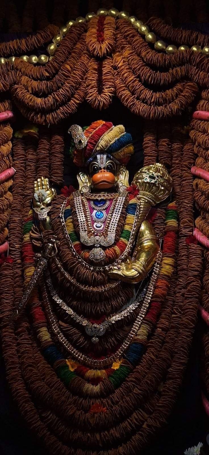 an elaborately decorated statue in the form of a person with two hands on his chest