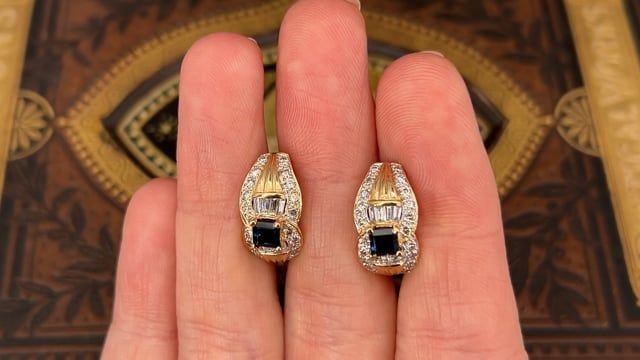 These exquisite vintage earrings are each accented with one (1), prong set, square step cut natural sapphire, eight (8), channel set, baguette cut diamonds and twenty (20), bead set, round brilliant cut diamonds. The earrings measure 17.8mm X 9.3mm and are finished with omega style backs. Elegant Gemstone Baguette-cut Earrings, Evening Jewelry With Baguette Diamonds In Rectangular Shape, Elegant Channel Set Diamond Earrings, Rectangular Baguette Diamond Jewelry For Evening, Elegant Baguette Diamond Earrings For Anniversary, Baguette Diamond Jewelry For Evening, Luxury Channel Set Earrings For Wedding, Elegant Diamond Earrings With Channel Set, Fine Jewelry Baguette Diamond Earrings For Anniversary