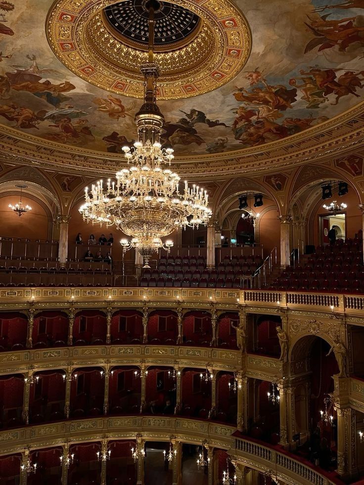 a chandelier hangs from the ceiling in an ornately decorated auditorium