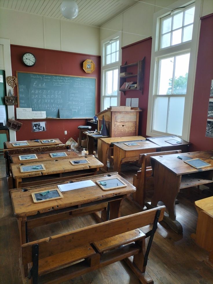 an old school room with wooden desks and chalkboard