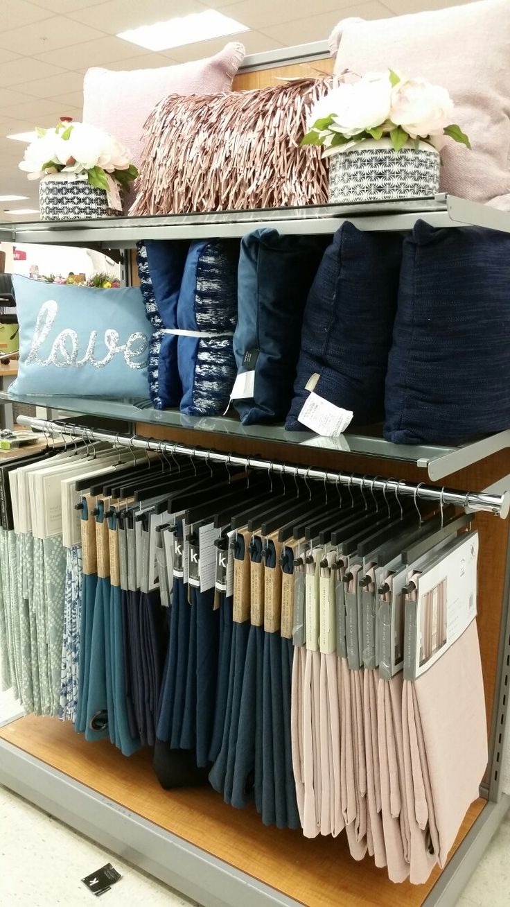 the shelves are full of folded clothes and pillows for sale at the clothing section in the store