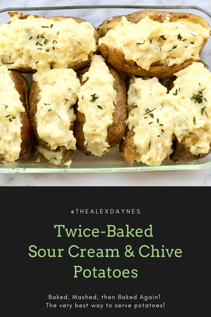 two baked sour cream and chive potatoes in a glass baking dish on a marble counter top