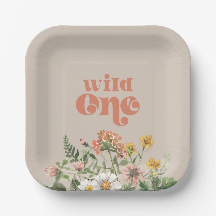 a paper plate with the words wild one printed on it and flowers in the middle