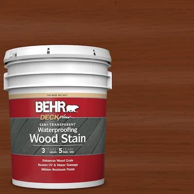 a bucket of wood stain sitting on top of a wooden floor next to a red wall